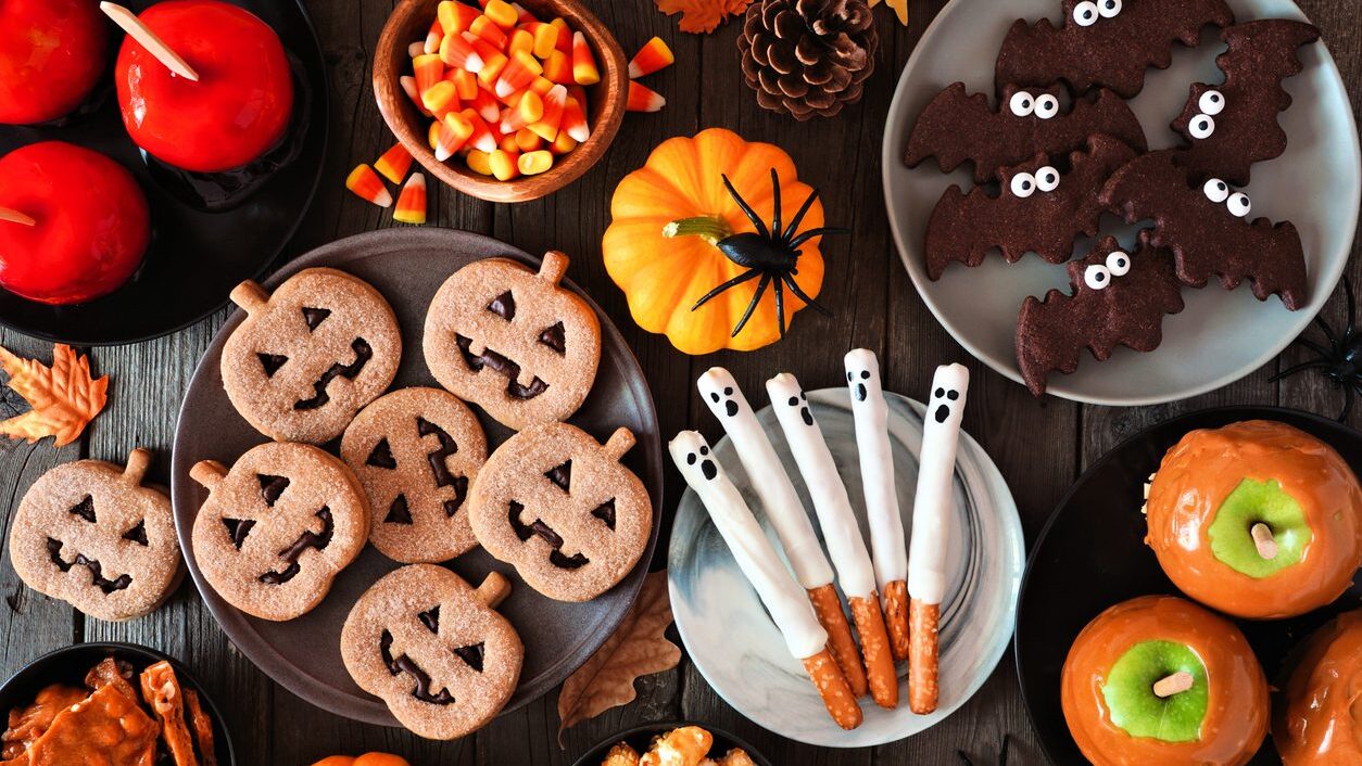 Halloween treat table scene, above view over a rustic dark wood background